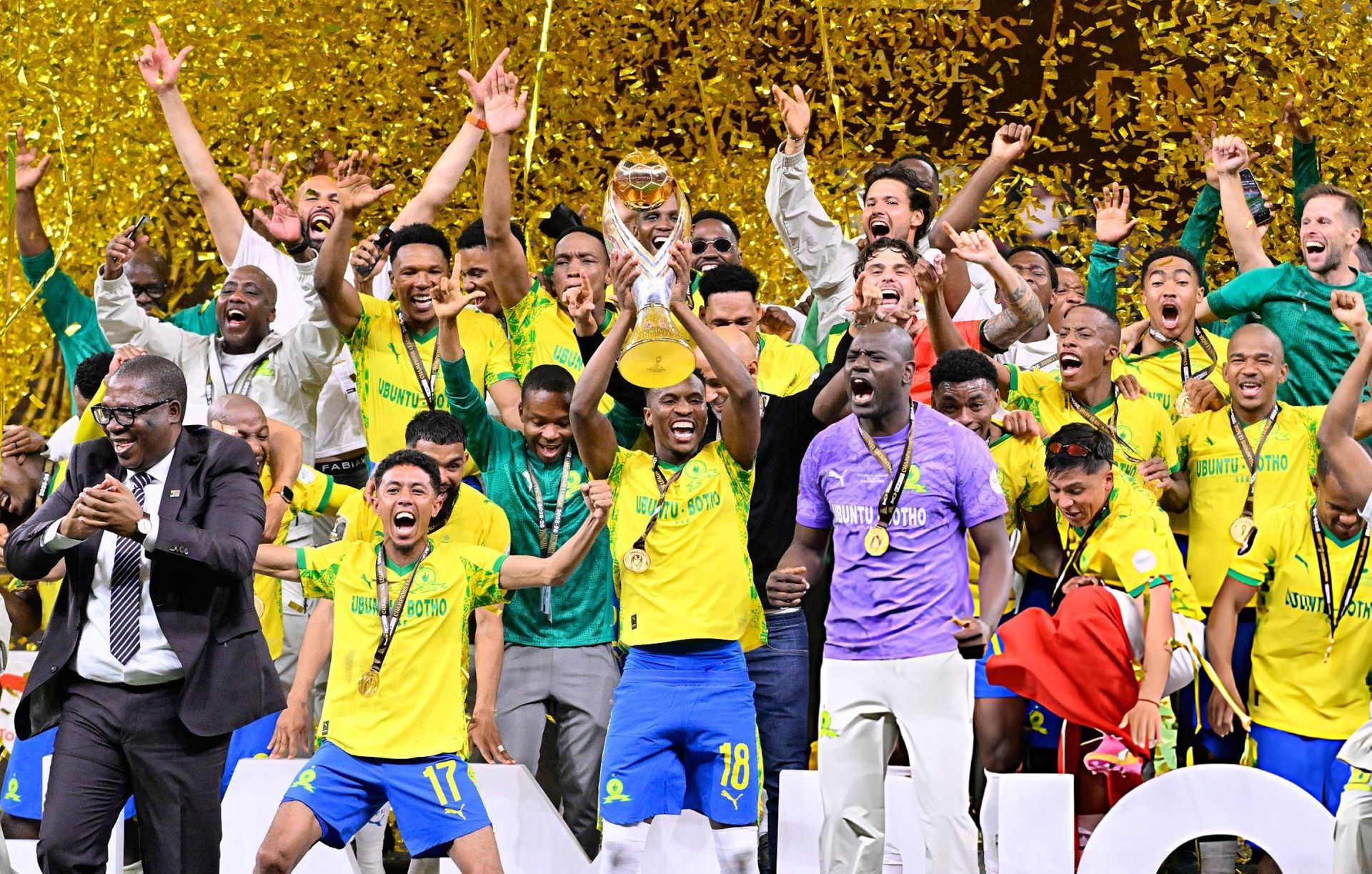 Mamelodi Sundowns players celebrate with the CAF Champions League trophy amid gold confetti