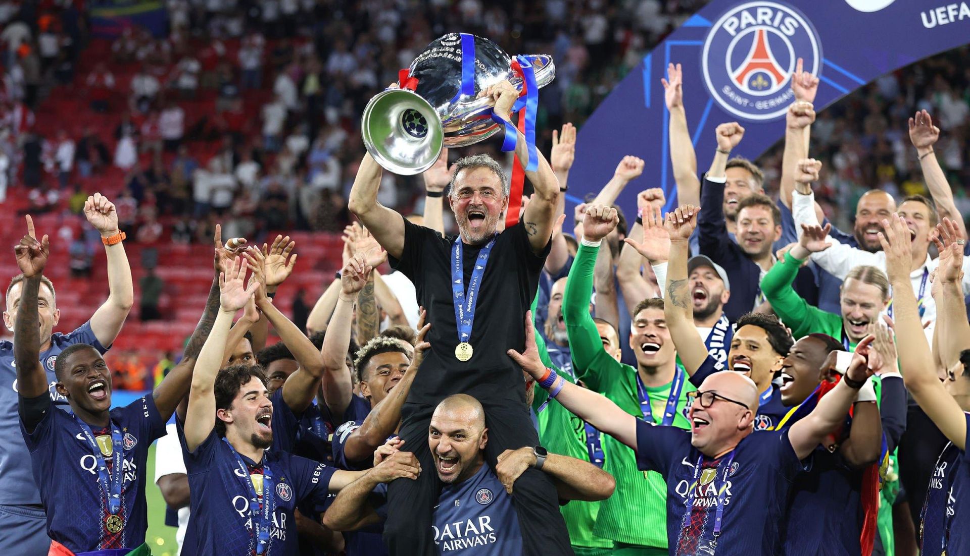 Luis Enrique lifts the Champions League trophy as PSG players celebrate becoming back-to-back champions