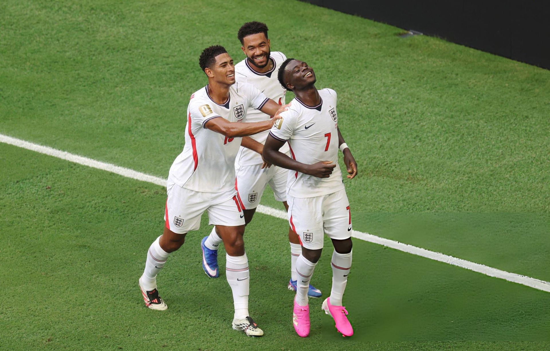 Bukayo Saka celebrates with Jude Bellingham and Reece James after scoring against France